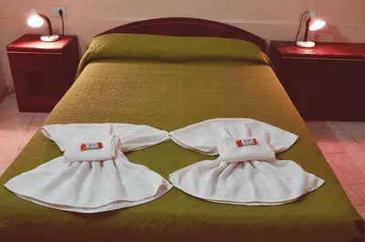 a bed with white towels on top of it at Hostel Ctalamochita in Embalse