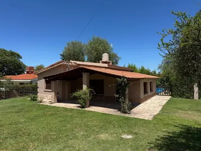 a small house with a grass yard in front of it at CASA PARA 6 PERSONAS MERLO SAN LUIS in Merlo
