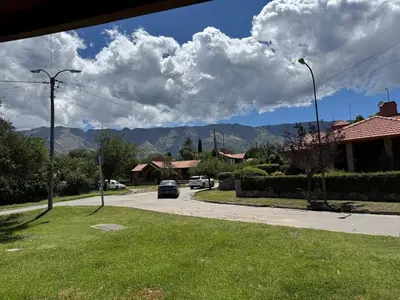 a car driving down a street with mountains in the background at CASA PARA 6 PERSONAS MERLO SAN LUIS in Merlo