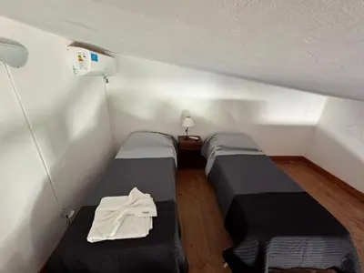a room with two beds in a small room at CASA PARA 6 PERSONAS MERLO SAN LUIS in Merlo
