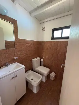 a bathroom with a toilet and a sink and a mirror at CASA PARA 6 PERSONAS MERLO SAN LUIS in Merlo