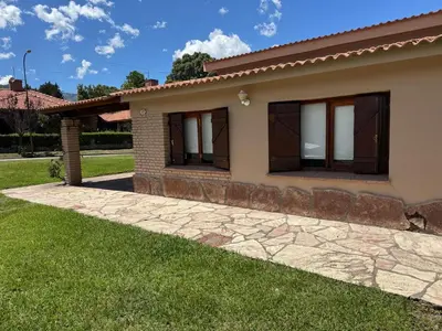 a house with a green lawn in front of it at CASA PARA 6 PERSONAS MERLO SAN LUIS in Merlo