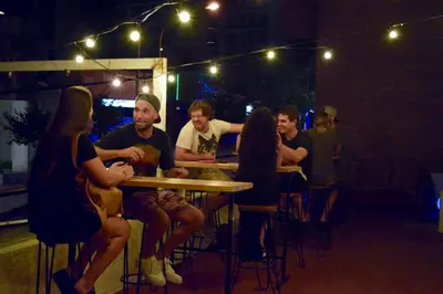 a group of people sitting at a table in a bar at Central Paz Hostel in Villa Carlos Paz