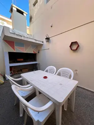 a white table and white chairs on a patio at Central Paz Hostel in Villa Carlos Paz