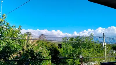 a view of trees and a blue sky with clouds at Apartamento Emir in Mina Clavero