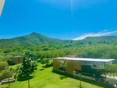 a truck parked in front of a building with mountains in the background at Apart Las Palmeras Corcovado in Villa Rumipal