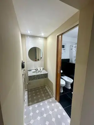 a bathroom with a sink and a mirror and a toilet at Apart Las Palmeras Corcovado in Villa Rumipal