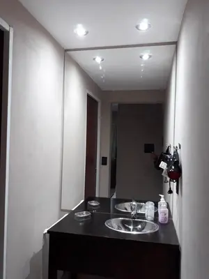 a person taking a picture of a bathroom mirror at Apart Las Palmeras Corcovado in Villa Rumipal