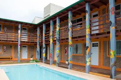 a building with a swimming pool in front of it at Eirú Hostel in Santa Rosa de Calamuchita