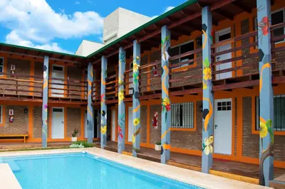 a building with a swimming pool in front of it at Eirú Hostel in Santa Rosa de Calamuchita