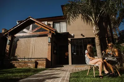 two women sitting on a chair in front of a house at Casa Nuestra in Cordoba