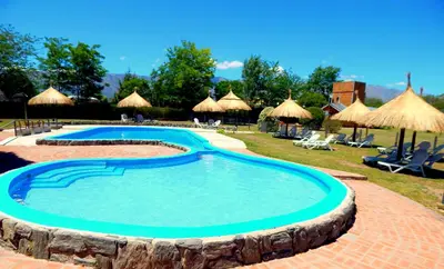 a swimming pool in a resort with chairs and umbrellas at Pachanavira Cabañas & Suites in Nono