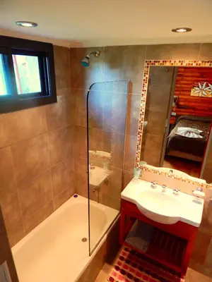 a bathroom with a tub and a sink and a shower at Pachanavira Cabañas & Suites in Nono