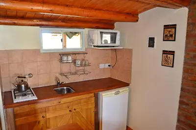 a small kitchen with a sink and a microwave at Pachanavira Cabañas & Suites in Nono