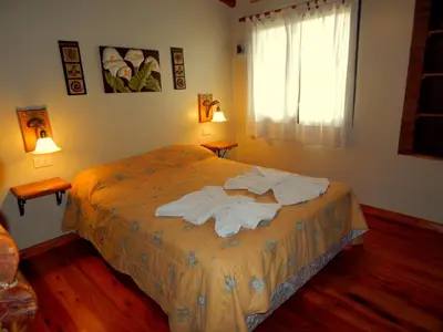 a bedroom with a bed with towels on it at Pachanavira Cabañas & Suites in Nono