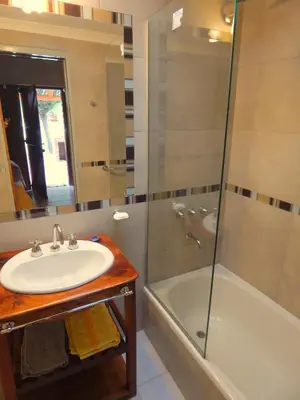 a bathroom with a sink and a shower and a tub at Pachanavira Cabañas & Suites in Nono