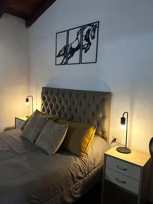 a bedroom with a large bed with two lamps on it at Tacuifi I - Apartamentos in Los Reartes
