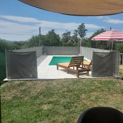 a swimming pool with a bench and an umbrella at La Allandesa in Cavalango
