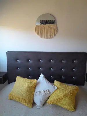 a bed with two pillows and a mirror on the wall at La Allandesa in Cavalango