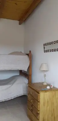 a bedroom with two bunk beds and a table with a lamp at La Allandesa in Cavalango