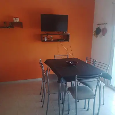 a dining room with a table with chairs and a television at La Allandesa in Cavalango