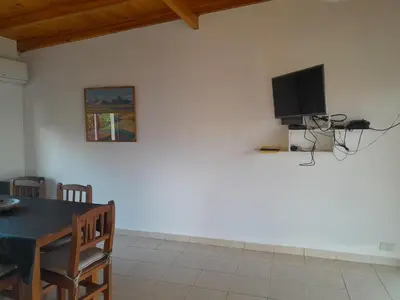 a living room with a table and a tv on a wall at La Allandesa in Cavalango