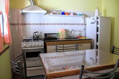 a kitchen with a table and a stove and a refrigerator at flia Fortuna2 in Mina Clavero