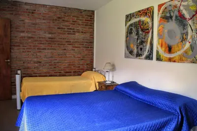 a bedroom with two beds and a brick wall at flia Fortuna2 in Mina Clavero