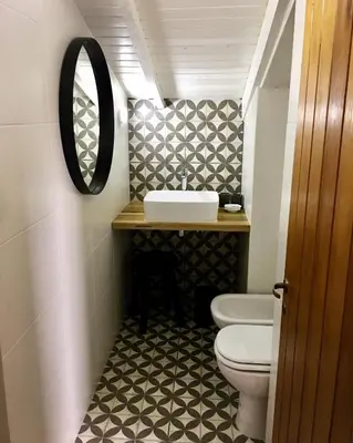 a bathroom with a sink and a toilet and a mirror at La Franca Cabaña de Veraneo in Villa General Belgrano