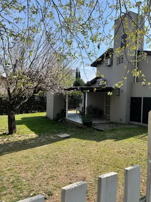 a white house with a fence in front of it at La Franca Cabaña de Veraneo in Villa General Belgrano