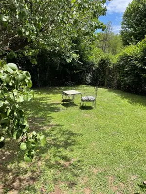 a table and a bench sitting in a yard at La Franca Cabaña de Veraneo in Villa General Belgrano