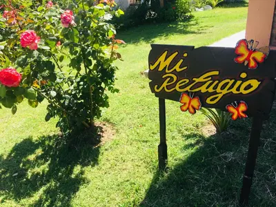 a sign for a yard with flowers on it at Mi Refugio in Merlo