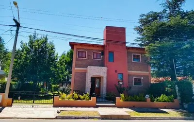 a red brick building with plants in front of it at Mi Refugio in Merlo