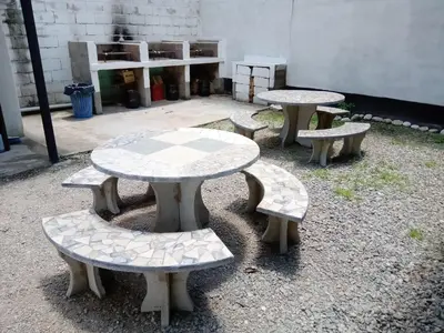 a group of tables and benches in a courtyard at Hostería El Peregrino in Villa Cura Brochero