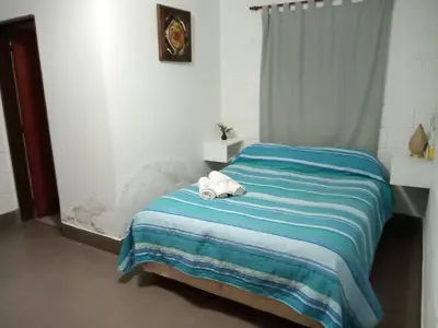 a bed with a stuffed animal on top of it at Hostería El Peregrino in Villa Cura Brochero