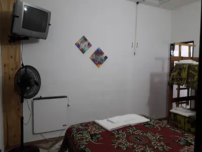 a room with a tv and a bed and a mirror at La Nona in Villa Cura Brochero