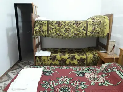 a bedroom with a bed and a couch and a bedspread at La Nona in Villa Cura Brochero