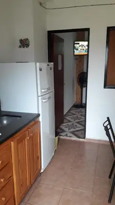 a kitchen with a white refrigerator and a hallway at La Nona in Villa Cura Brochero