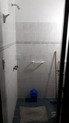 a bathroom with a shower with a blue bucket at La Nona in Villa Cura Brochero