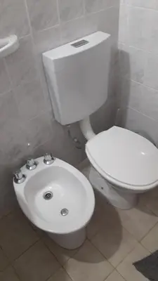 a bathroom with a white toilet and a sink at La Nona in Villa Cura Brochero