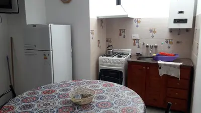 a kitchen with a refrigerator and a table in it at La Nona in Villa Cura Brochero