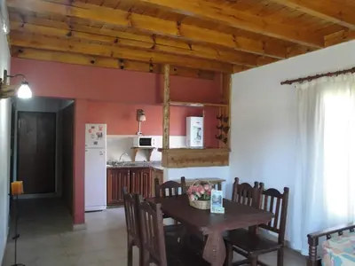 a kitchen and dining room with a table and chairs at Chalets Los Abedules in Villa General Belgrano