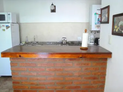 a kitchen with a brick counter top and a refrigerator at Chalets Los Abedules in Villa General Belgrano