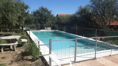 a swimming pool with a fence around it at Cabañas Corazon de Maria in Merlo