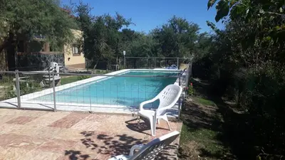 a swimming pool with a white chair next to it at Cabañas Corazon de Maria in Merlo