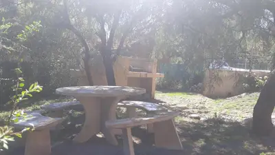 a picnic table and two benches in a yard at Cabañas Corazon de Maria in Merlo