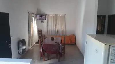a dining room with a table and a kitchen at Cabañas Corazon de Maria in Merlo