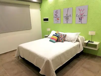 a bedroom with a bed with green walls at Altos de Chacabuco Planta Baja Apartamento exclusivo premium con cochera gratis in Cordoba