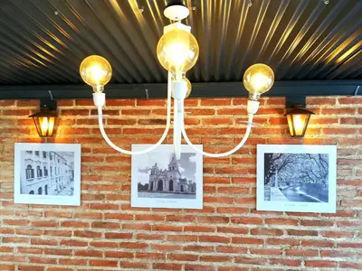 a group of pictures on a brick wall with lights at Altos de Chacabuco Planta Baja Apartamento exclusivo premium con cochera gratis in Cordoba