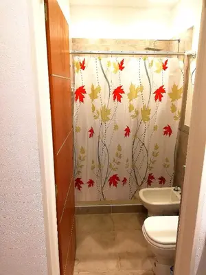 a bathroom with a toilet and a shower curtain with autumn leaves at Altos de Chacabuco Planta Baja Apartamento exclusivo premium con cochera gratis in Cordoba